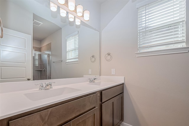 full bath featuring a sink, a stall shower, double vanity, and visible vents