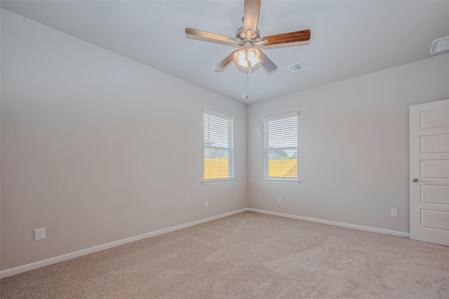 unfurnished room featuring baseboards, a ceiling fan, light colored carpet, and visible vents