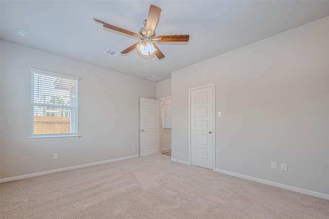 unfurnished bedroom featuring carpet floors, baseboards, ceiling fan, and visible vents