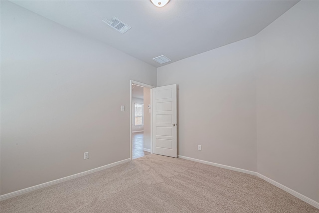 unfurnished room with baseboards, carpet floors, and visible vents