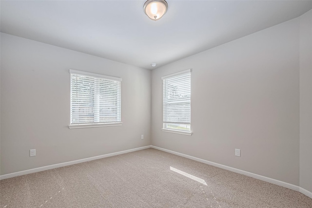 empty room with baseboards and light colored carpet