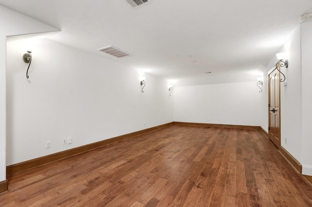 empty room with visible vents, baseboards, and wood finished floors