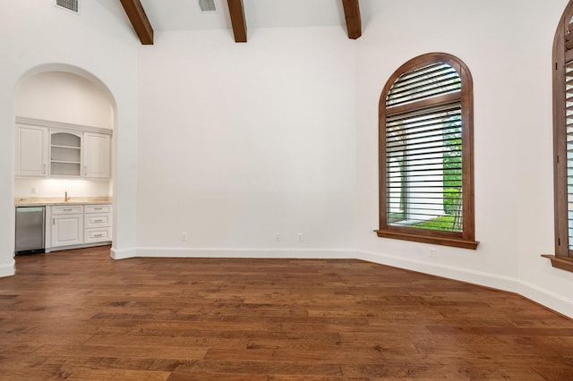 interior space with visible vents, dark wood-style flooring, beam ceiling, baseboards, and wet bar