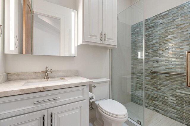 full bathroom with vanity, a stall shower, and toilet