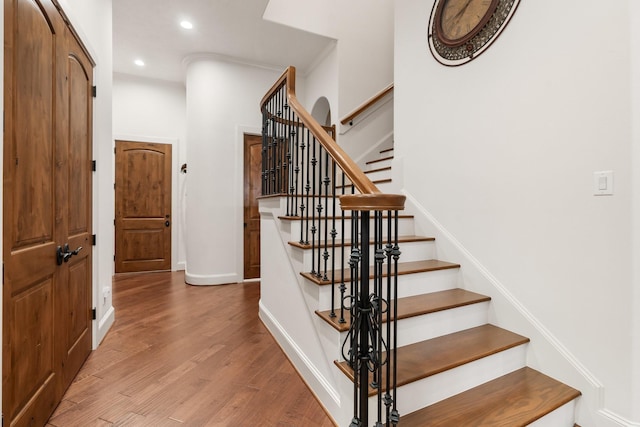 staircase with recessed lighting, baseboards, and wood finished floors