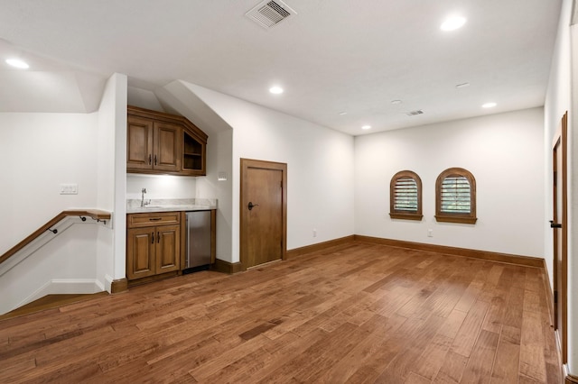 bar with light wood-style floors, recessed lighting, refrigerator, and visible vents