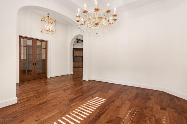 unfurnished dining area featuring arched walkways, baseboards, french doors, and a chandelier