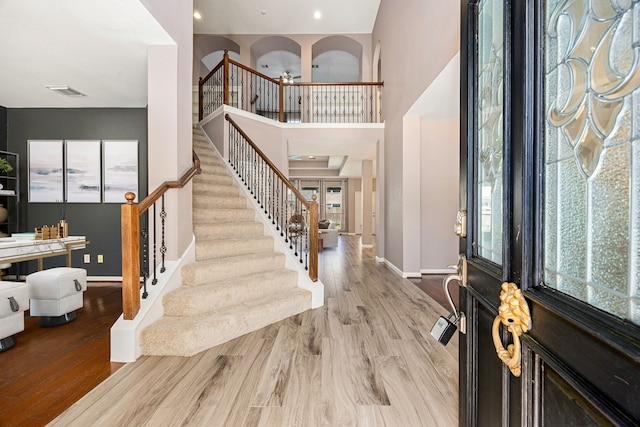 foyer entrance featuring baseboards, stairs, and a wealth of natural light