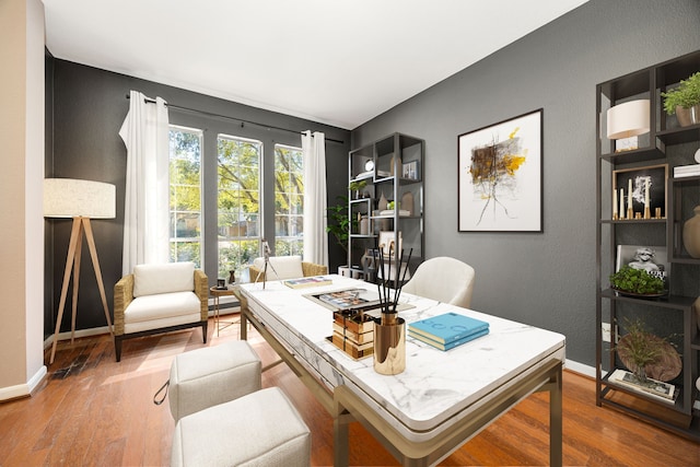 home office featuring baseboards, a textured wall, and wood finished floors