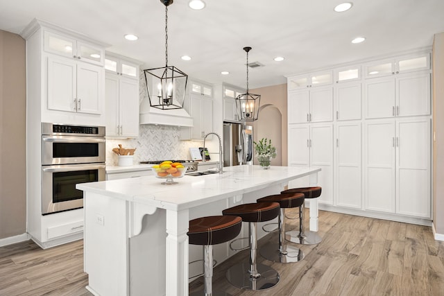 kitchen featuring visible vents, recessed lighting, light wood-type flooring, tasteful backsplash, and stainless steel appliances