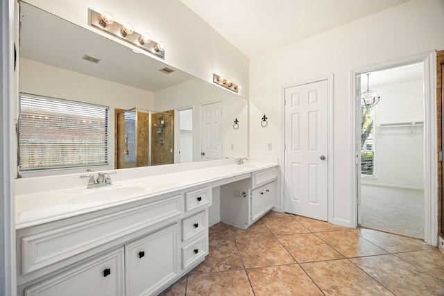 full bathroom featuring visible vents, double vanity, tile patterned floors, a shower stall, and a sink