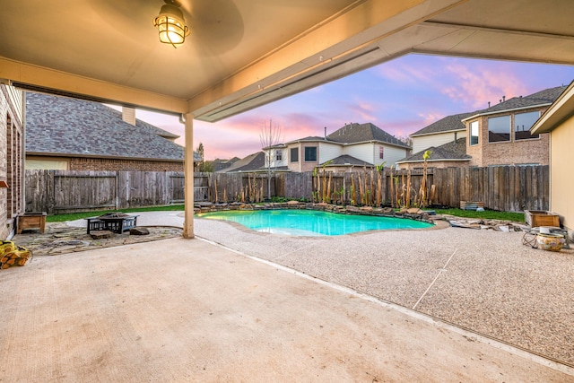 view of pool with a patio, a fenced backyard, and a fire pit