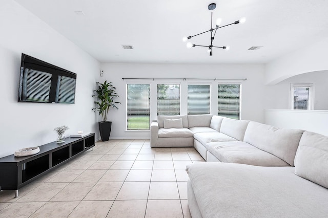 living room with visible vents, baseboards, light tile patterned flooring, and a notable chandelier