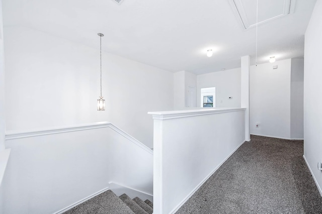 corridor featuring attic access, baseboards, carpet flooring, and an upstairs landing