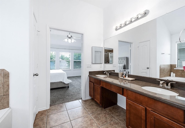 full bath with a sink, a washtub, tile patterned floors, connected bathroom, and double vanity