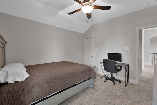 bedroom with light carpet, baseboards, vaulted ceiling, ceiling fan, and an office area