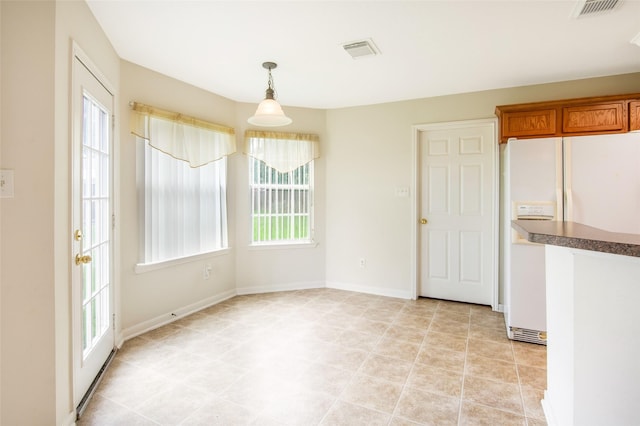 unfurnished dining area with baseboards and visible vents