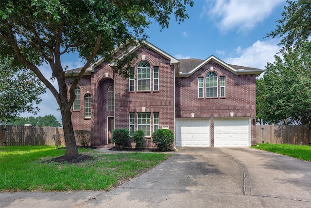 traditional-style home featuring brick siding, an attached garage, fence, and driveway