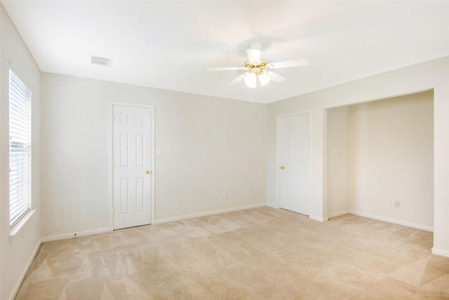 unfurnished room featuring visible vents, baseboards, ceiling fan, and light colored carpet