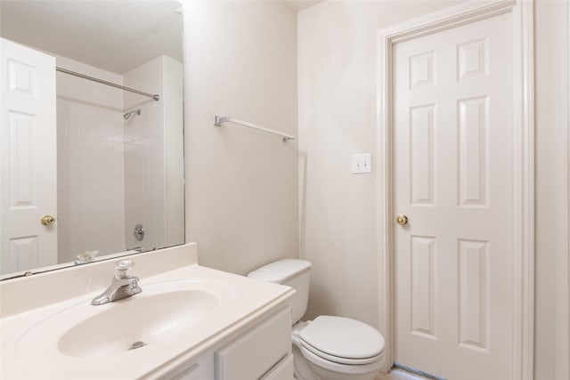 bathroom featuring vanity, walk in shower, and toilet