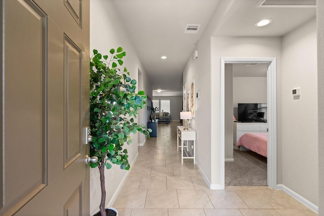 hallway featuring light tile patterned floors, baseboards, recessed lighting, and visible vents