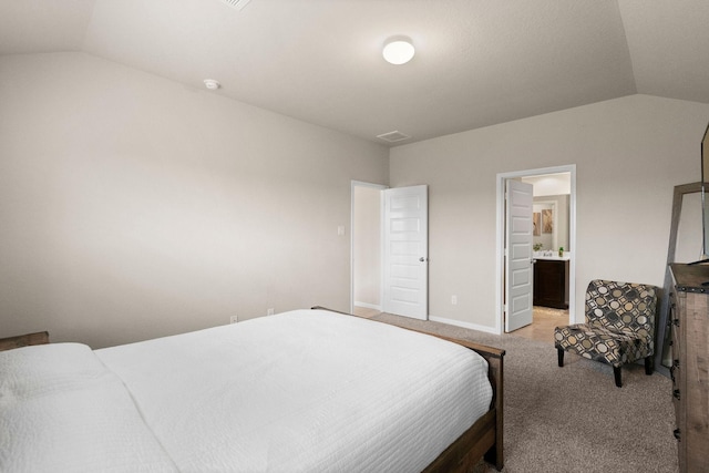 bedroom with carpet flooring, baseboards, connected bathroom, and lofted ceiling