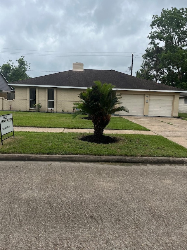 ranch-style home with concrete driveway, brick siding, a front yard, and a garage
