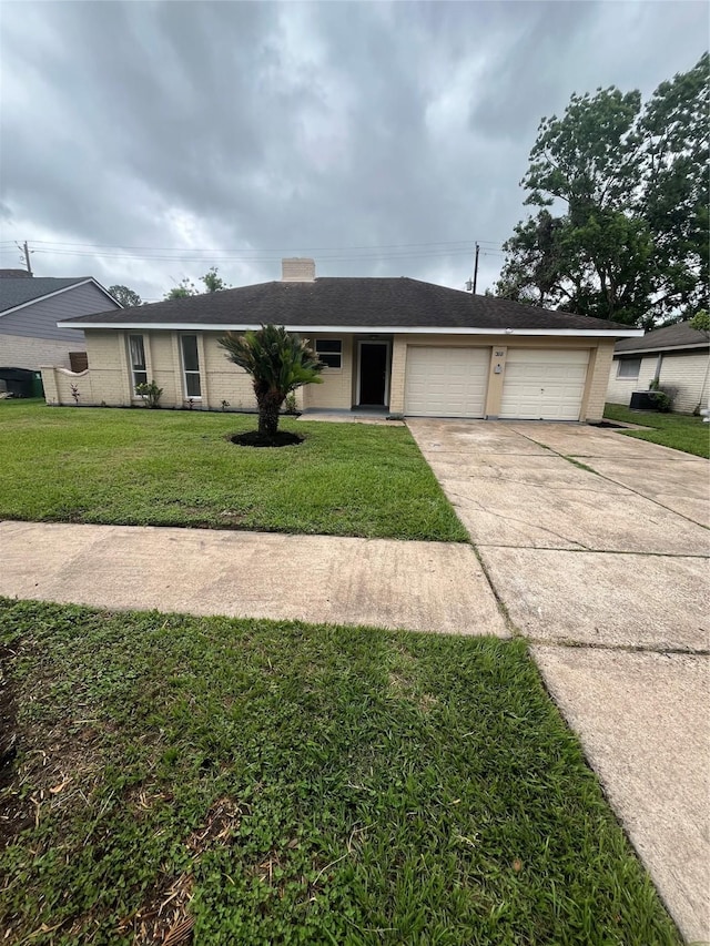 ranch-style house with concrete driveway, a garage, and a front yard