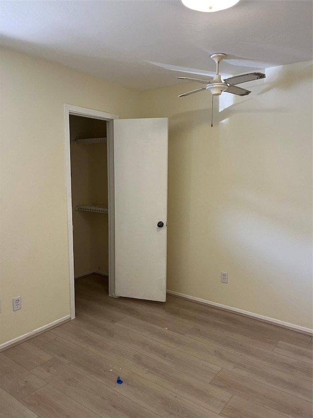 unfurnished bedroom featuring light wood-type flooring, baseboards, a closet, and a ceiling fan