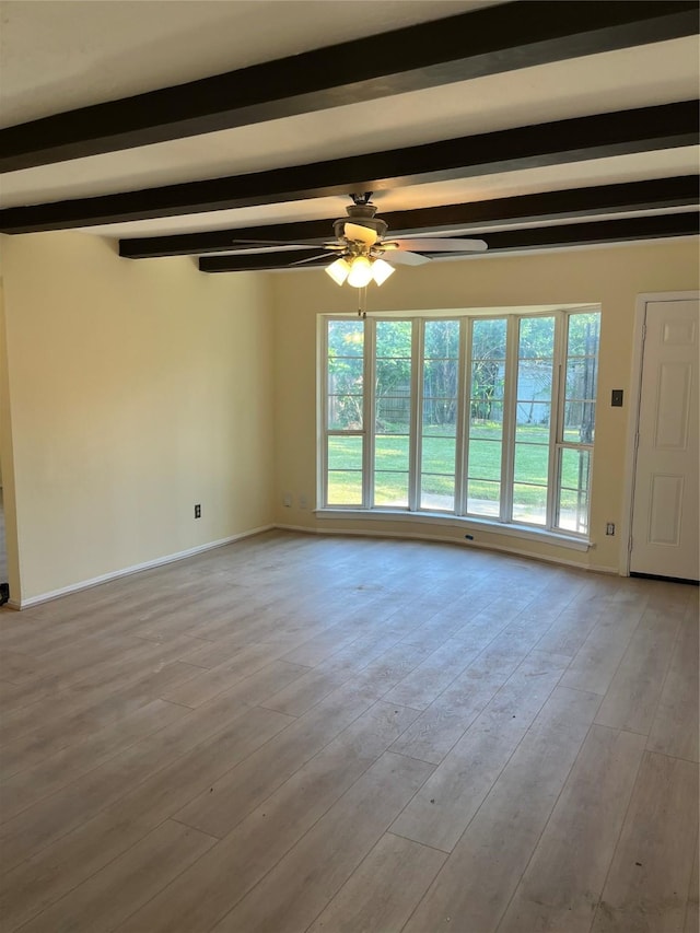 unfurnished living room with a ceiling fan, beam ceiling, wood finished floors, and baseboards