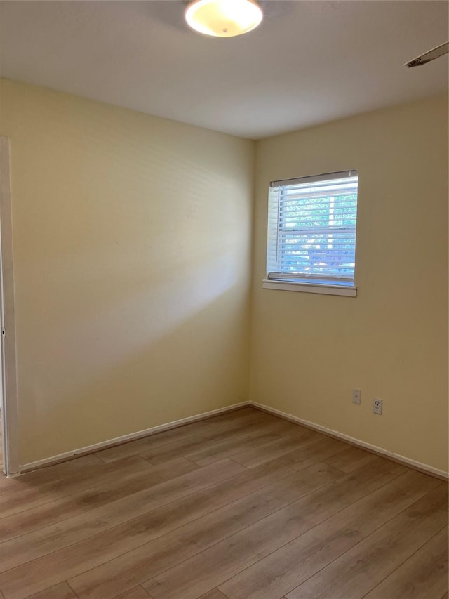 unfurnished room with light wood finished floors and baseboards