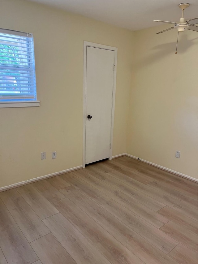 empty room featuring light wood-style floors, ceiling fan, and baseboards