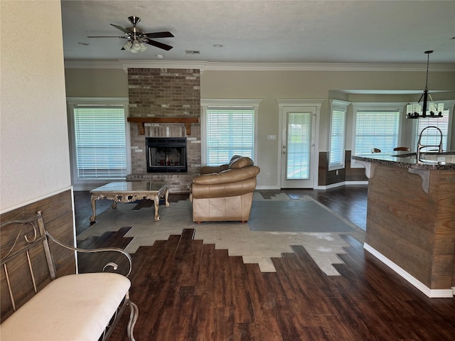 13796 County Road 318, Navasota, TX 77868 - living room featuring a ceiling fan, wood finished floors, healthy amount of natural light, a fireplace, and crown molding