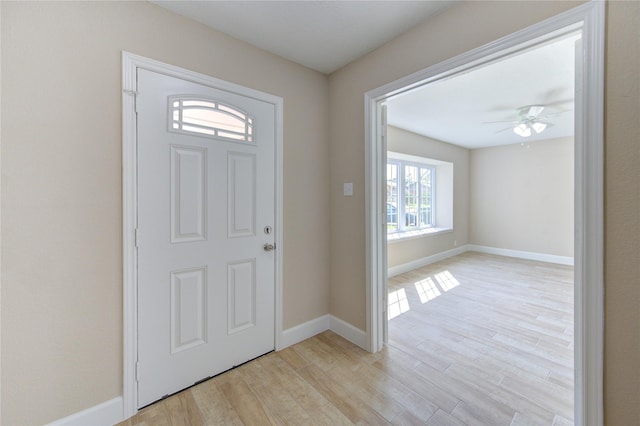 foyer with baseboards, ceiling fan, and light wood-style flooring