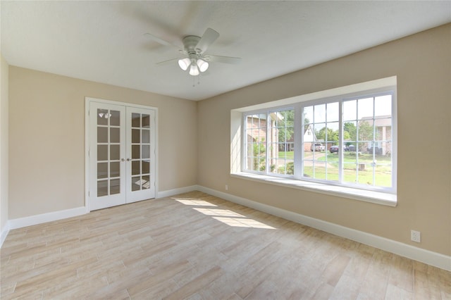 unfurnished room featuring baseboards, ceiling fan, and french doors