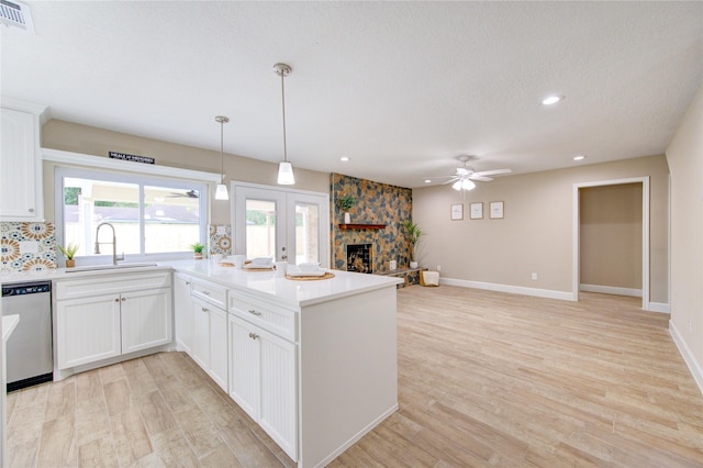 kitchen with a peninsula, ceiling fan, visible vents, and dishwasher