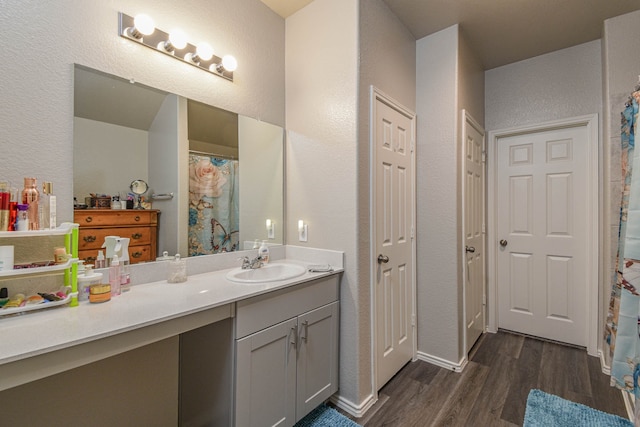 9971 Spring Creek Rd, Cleveland, TX 77327 - bathroom featuring baseboards, a textured wall, wood finished floors, and vanity