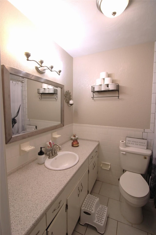 402 E Smith St, Brazoria, TX 77422 - bathroom with tile patterned floors, toilet, vanity, tile walls, and a shower with shower curtain