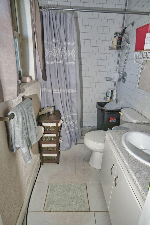 402 E Smith St, Brazoria, TX 77422 - bathroom with a shower stall, tile patterned flooring, tile walls, toilet, and vanity