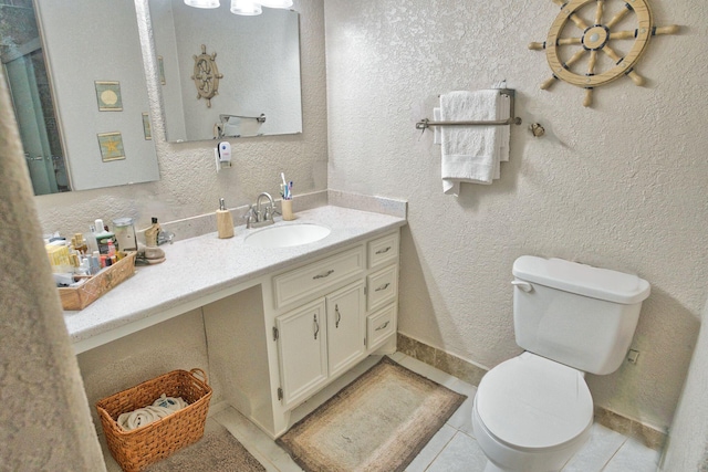 402 E Smith St, Brazoria, TX 77422 - bathroom with toilet, vanity, tile patterned flooring, a textured wall, and baseboards