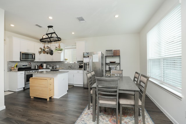 12626 Baker Bend St, Houston, TX 77034 - kitchen with a kitchen island, visible vents, tasteful backsplash, stainless steel appliances, and white cabinetry