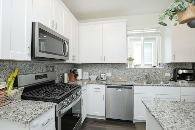 12626 Baker Bend St, Houston, TX 77034 - kitchen featuring white cabinets, appliances with stainless steel finishes, light stone counters, a sink, and decorative backsplash