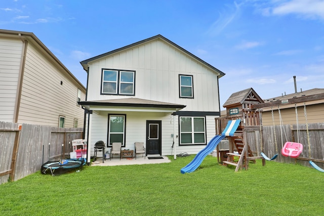 12626 Baker Bend St, Houston, TX 77034 - rear view of house with board and batten siding, a lawn, a fenced backyard, a playground, and a patio