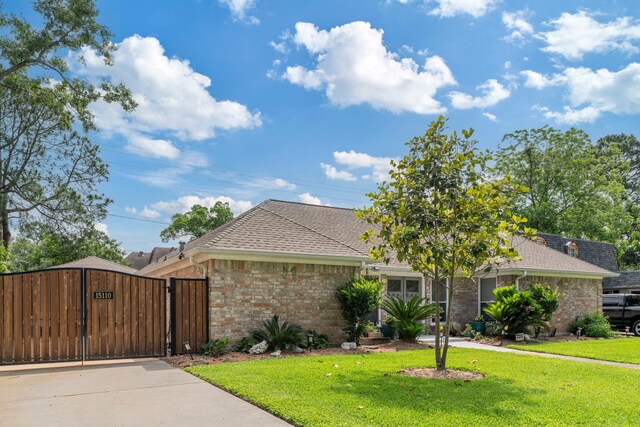 15110 Falling Creek Dr, Houston, TX 77068 - single story home featuring brick siding, a front lawn, a gate, and roof with shingles