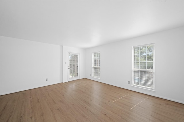 unfurnished room with baseboards and wood finished floors