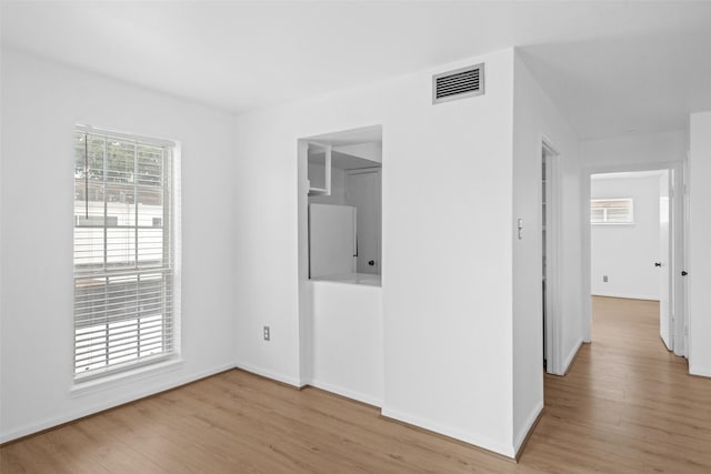 interior space featuring baseboards, wood finished floors, and visible vents