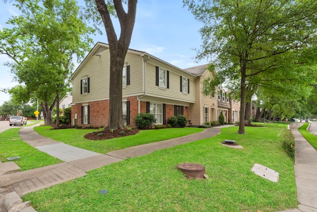 colonial home with brick siding and a front yard