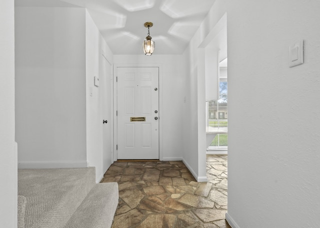 entrance foyer featuring stone flooring and baseboards