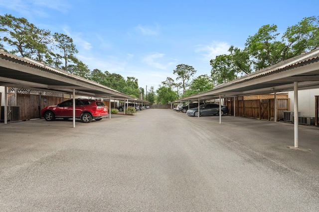covered parking lot featuring fence