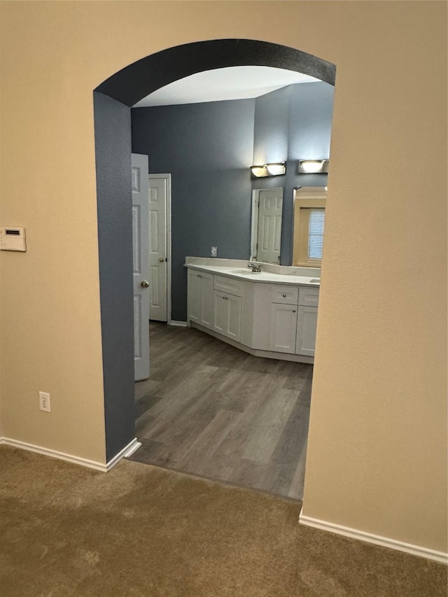 bathroom with baseboards, vanity, and wood finished floors